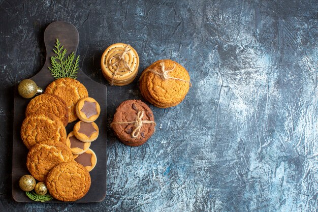 Top view different tasty biscuits on light-dark table christmas sweet new year sugar cookie tea free space