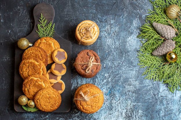 Top view different tasty biscuits on a light-dark table christmas sweet new year sugar cookie tea