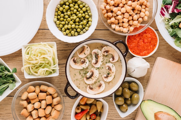 Top view of dishes with mushroom soup and olives