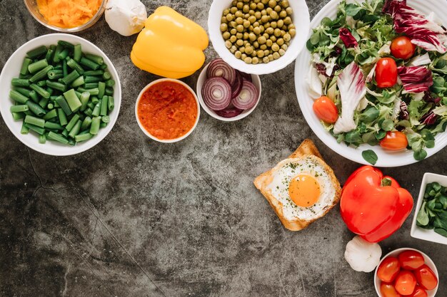 Top view of dishes with salad and fried egg on toast