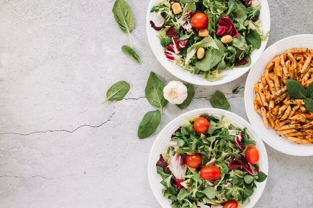 Top view of dishes with salads and garlic with copy space