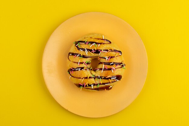 top view donut chocolate inside orange plate on the yellow floor