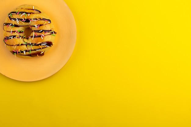 top view donut yummy inside orange plate on the yellow desk