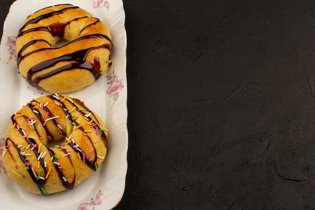 top view donuts yummy delicious inside glass plate on the dark