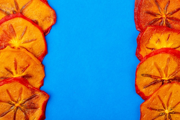 Free Photo top view of dried persimmon slices isolated on blue background with copy space