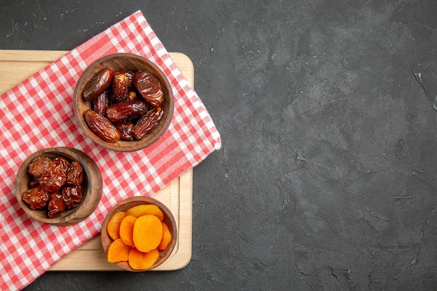 Free photo top view dry khurma with dried apricots on dark surface fruit dry raisin