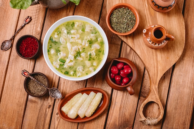 Top view of dushbara dumpling soup served with dried herbs and spices