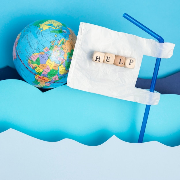 Free photo top view of earth globe with plastic straw and paper ocean waves