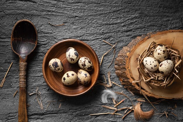 Top view of easter eggs in bird nest and plate with wooden spoon