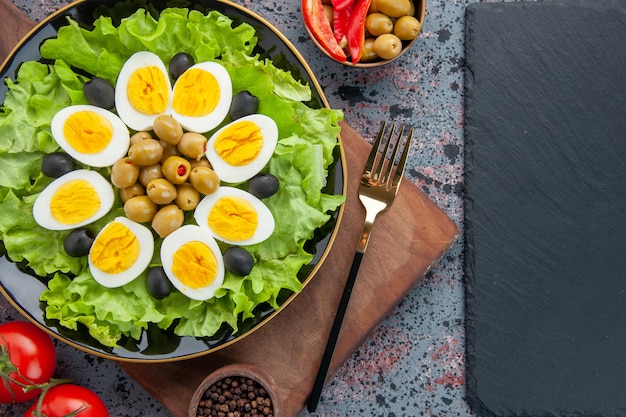 top view egg salad green salad and olives on light background