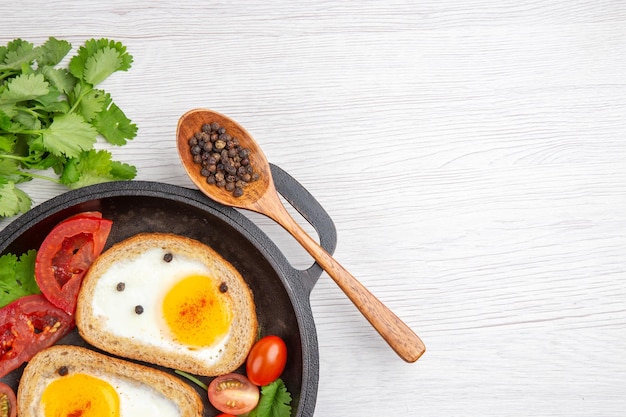 Free photo top view egg toasts with tomatoes and greens on white background breakfast lunch meal color photo morning salad