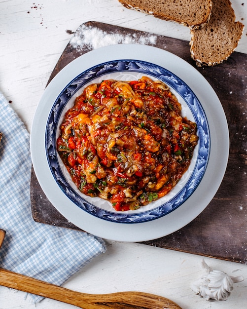 Top view of eggplant caviar with herbs on a plate