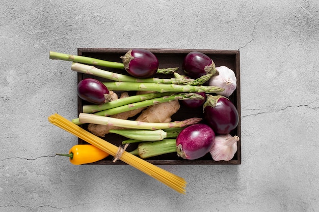 Top view eggplants, assparagus and raw spaghetti