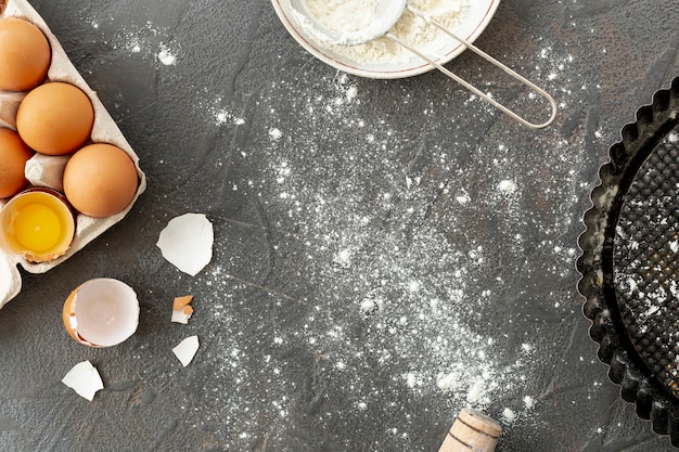 Free photo top view of eggs sieve and tray on plain background