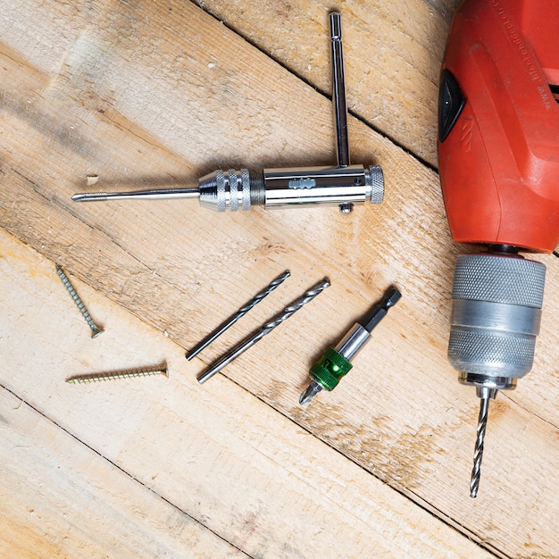 Free Photo top view of an electric drill, nails and other repairing equipments on a wooden surface