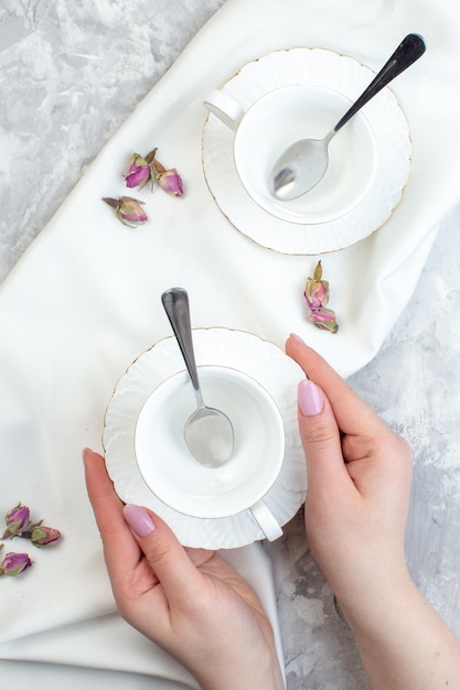 Top view elegant cups with plate spoons and flowers on white surface horizontal colour glass food cuisine kitchen table