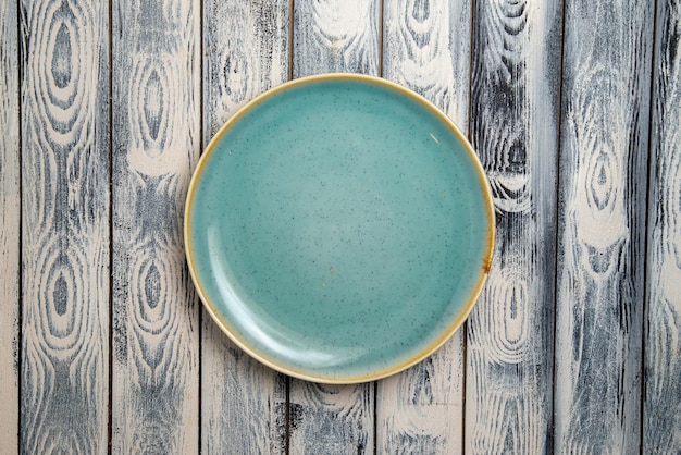 Top view empty glass plate green ed on grey rustic surface