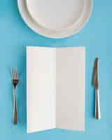 Free photo top view of empty menu paper with plates and cutlery