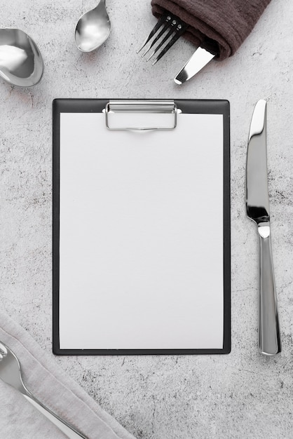 Top view of empty menu with forks and knives