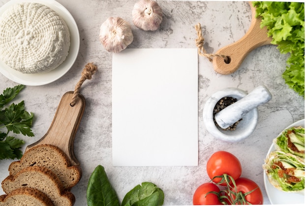 Top view of empty menu with tomatoes and garlic