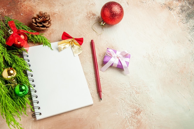 Top view empty open notepad with green branch and toys