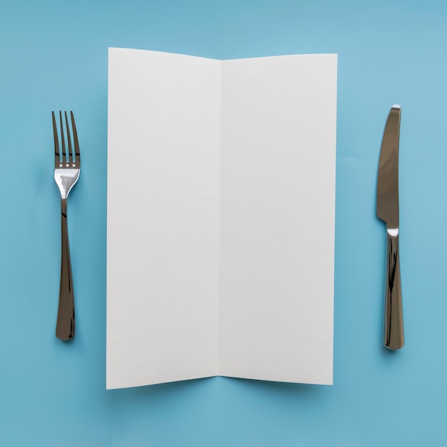 Free Photo top view of empty paper with fork and knife