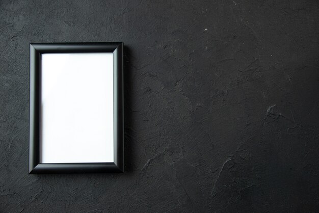 Top view of empty picture frame on the dark wall