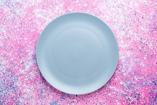 Top view empty plate blue colored on the pink wall color photo plate food