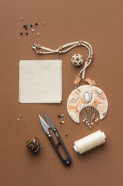 Top view of essentials for bead working with scissors and thread