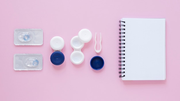 Top view eye care accessories on pink background