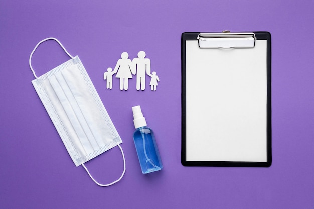 Top view of family made of paper with clipboard and medical mask