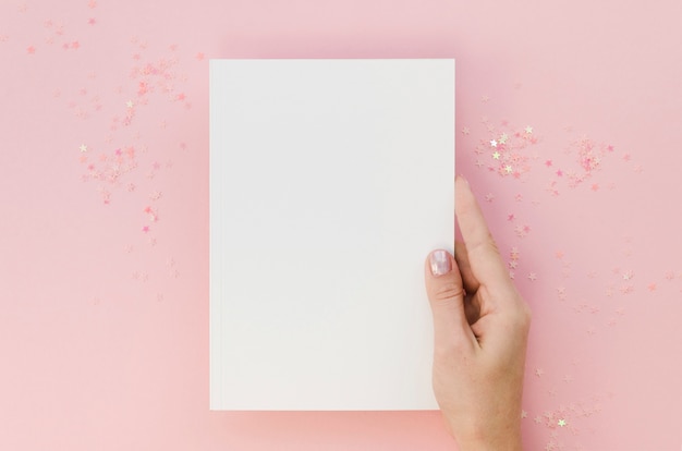 Top view of female hand holding notebook