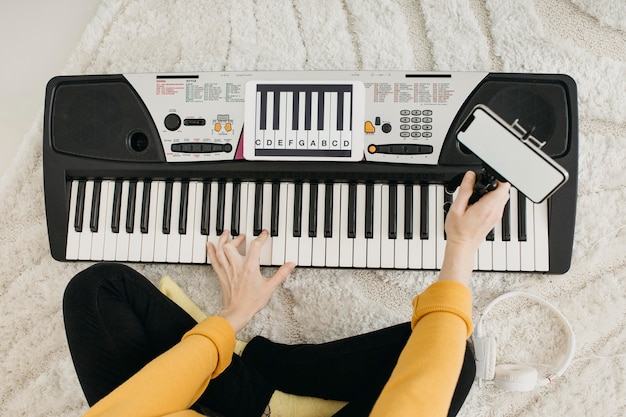 Free photo top view of female musician blogger streaming at home with smartphone