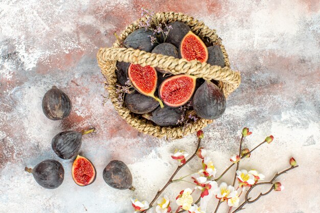 Top view fig basket figs apricot blossom branch on grey background