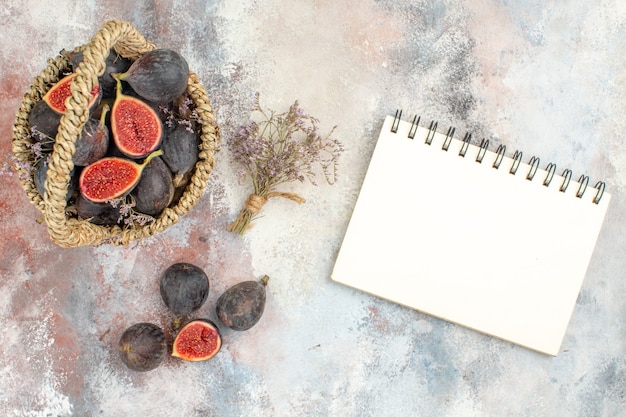 Free photo top view fig basket figs dried flower bunch a notebook on grey background