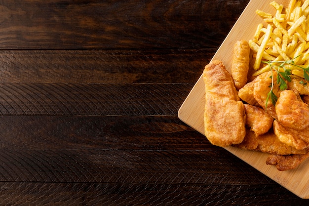 Top view of fish and chips on chopping board with copy space