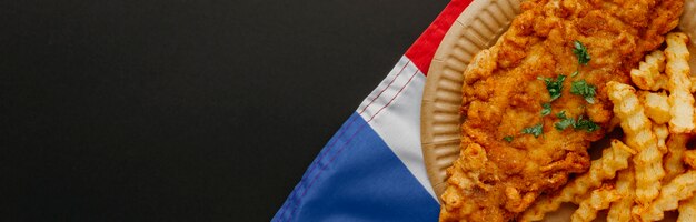 Top view of fish and chips on plate with great britain flag and copy space