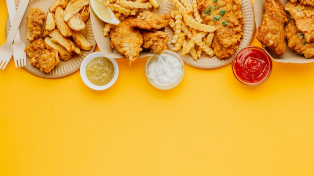 Top view of fish and chips with copy space and variety of sauces