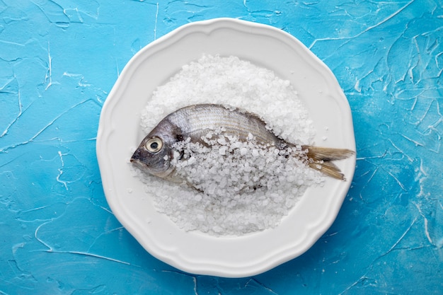 Top view of fish on plate with salt