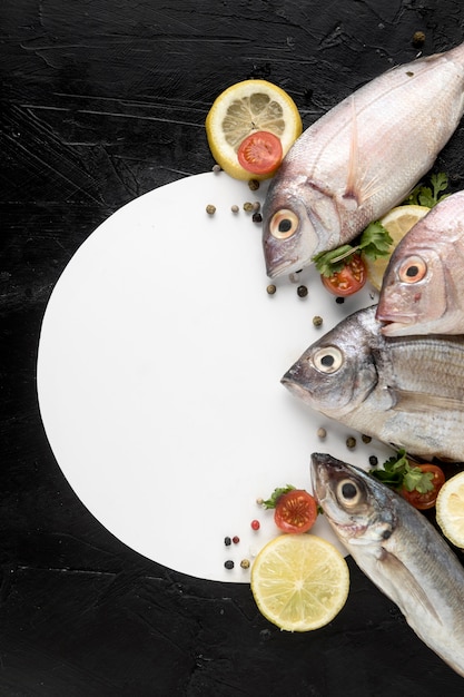 Free photo top view of fish with plate and lemon