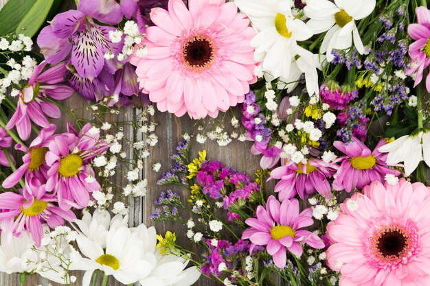 Top view floral arrangement on wooden background