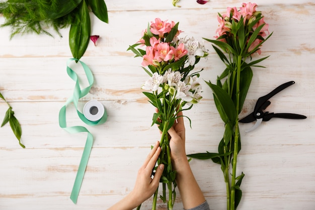 Free photo top view florist hands making bouquet