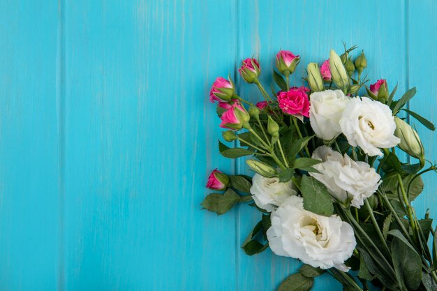 Top view of flowers on blue background with copy space