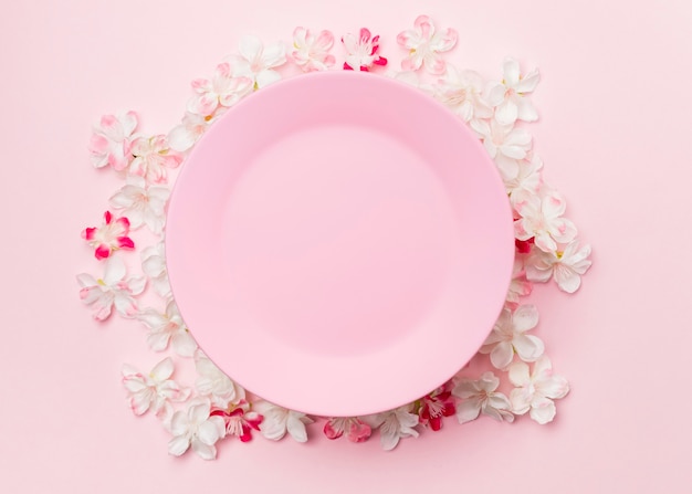 Free photo top view flowers and pink plate