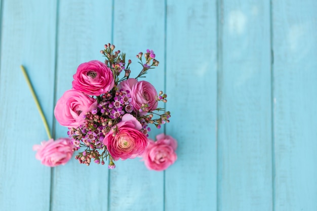 Top view of flowers in pink tones on blue surface