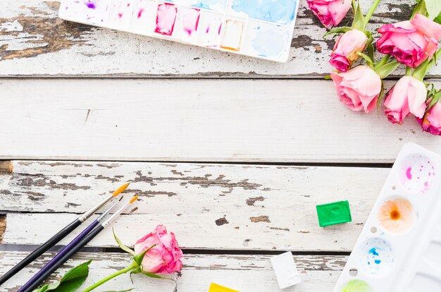 Top view flowers with painting material on wooden table