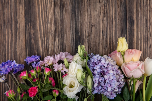 Top view of flowers on wooden background with copy space