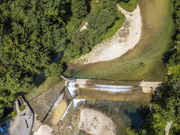 Top view of a flowing river next to a forest