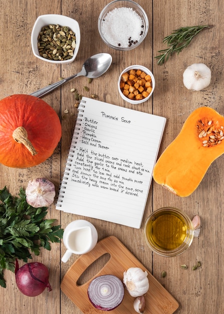 Free photo top view of food ingredients with notebook and pumpkin