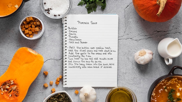 Top view of food ingredients with veggies and notebook